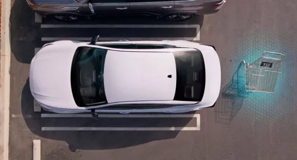 Top view of a white 2027 Nissan Altima in a parking lot with rear sensors detecting a shopping cart behind it at Faulkner Nissan of Harrisburg in Harrisburg PA